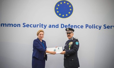 Woman stands beside man wearing a police uniform 