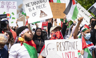 Protesters hold up posters and banners against Israeli air strikes in Gaza