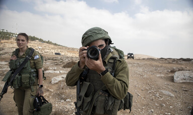 Man in uniform holds camera to his face