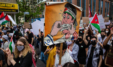 A group of protesters hold signs