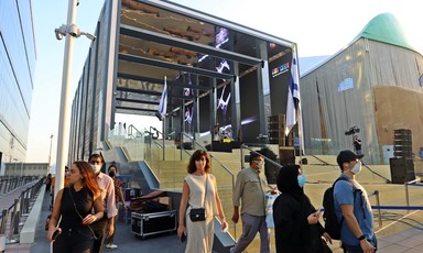 People walk around an exhibition structure 