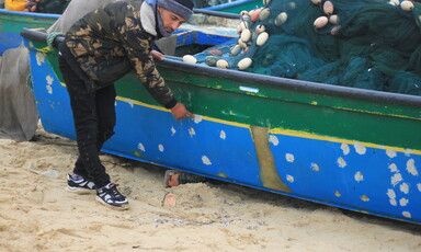Man stands beside boat 