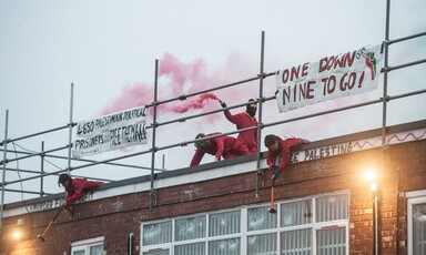 Activists on a rooftop smash windows