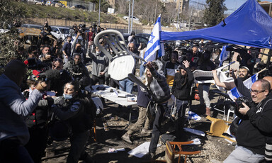 Men throw chairs in a crowd