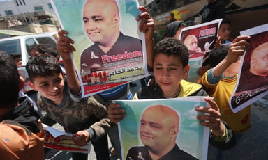 Smiling children hold posters featuring portrait of Mohammed El Halabi
