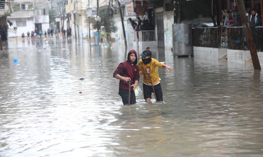 Two people walk through floods 