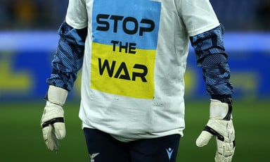 Man's torso wearing a shirt with the Ukrainian flag that reads "stop the war"