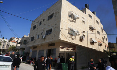 A three-story building with people milling about outside