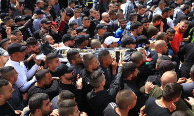 People carry the body of a boy on a stretcher 