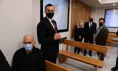 Ehud Olmert in court foreground with Netanyahus in background