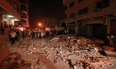 People stand around an area that has been severely damaged 