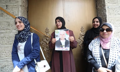 A woman holds up a picture of an imprisoned relative at a protest in Gaza