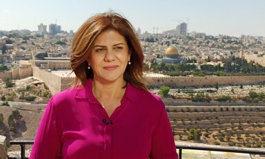 A woman stands with Jerusalem's skyline behind her