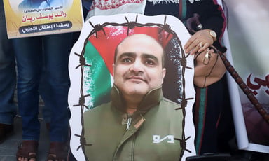Close-up of hand holding poster of Mohammed El Halabi's portrait