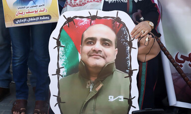 Close-up of hand holding poster of Mohammed El Halabi's portrait