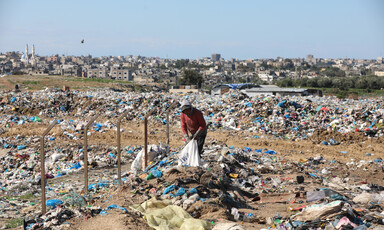 Boy holds plastic bag in a dump 