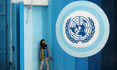 A boy looks up at the UN logo in Gaza City