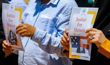 Two people hold up posters with "Justice for Shireen" written on them