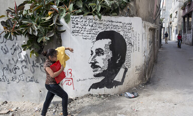 Girl walking beside a mural 