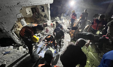 Palestinian rescue crew search beneath the rubble for survivors of an Israeli airstrike in Rafah