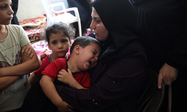 Palestinian woman hugs a crying child during a funeral