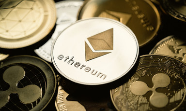 An ethereum coin lies atop several other digital currencies