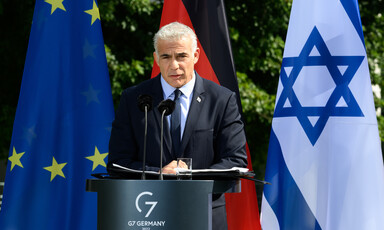 Man stands in front of flags 