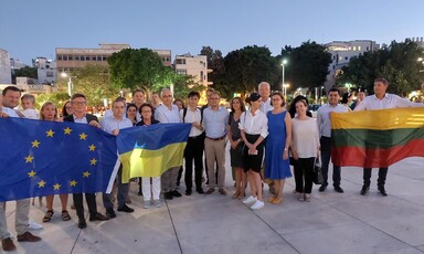 A group of people holds flags of EU and Ukraine and other countries