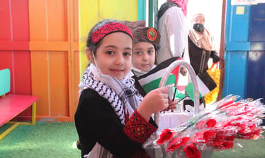 Palestinian child holds a bouquet of roses