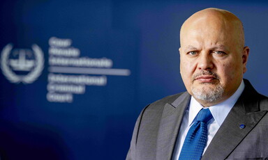 Close-up of Karim Khan viewed from chest up with ICC logo blurred out in background