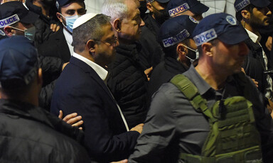 Two politicians walk alongside Israeli police officers