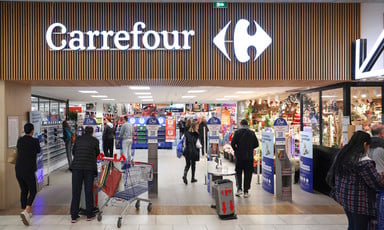 People walk in and out of the entrance of a Carrefour supermarket