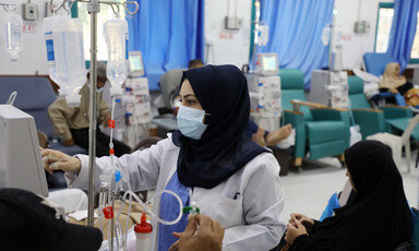 A doctor checks a screen in a hospital ward