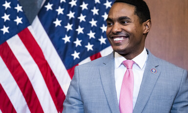 Congressman Ritchie Torres stands in front of an American flag