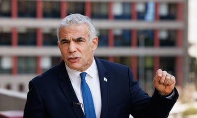 Prominent Israeli politician Yair Lapid wearing a dark suit and blue tie 