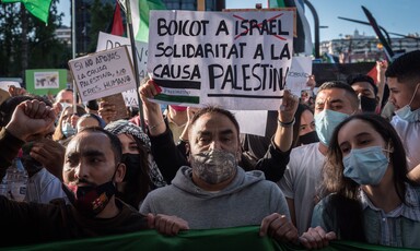 People hold signs at a demonstration calling for boycott of Israel