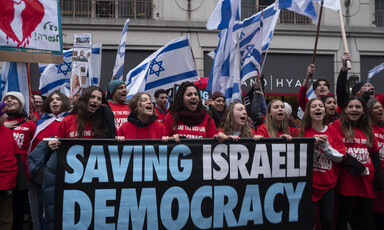 Protesters hold Israeli flags and other signs