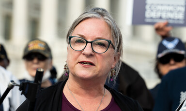 Congresswoman Susan Wild speaks at a press conference with veterans behind her