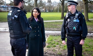 Britain's Home Secretary Suella Braverman chats with two uniformed police officers