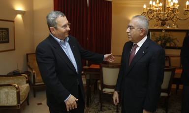 Ehud Barak and Salam Fayyad, both wearing suits, stand facing each other.