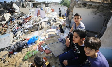 A few children beside the rubble of a Gaza building that has been destroyed in an Israeli airstrike. 