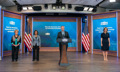 Man stands at podium flanked by other officials