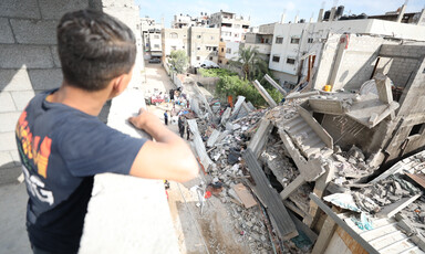 A child looks out over a destroyed house