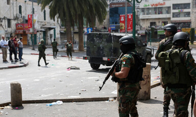 Palestinian Authority forces standing guard with a jeep