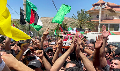 Corpse carried by men, surrounded by flags 