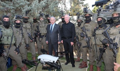 Israel's Prime Minister Benjamin Netanyahu and Defense Minister Yoav Gallant surrounded by soldiers wearing black masks and carrying weapons 