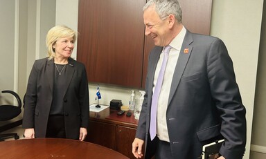 A woman and man stand next to a table and smile at eachother