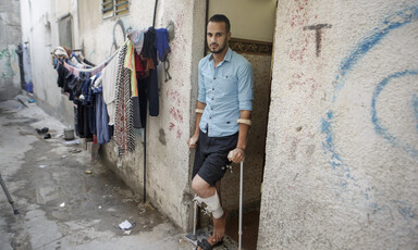 A man with crutches stands in a doorway