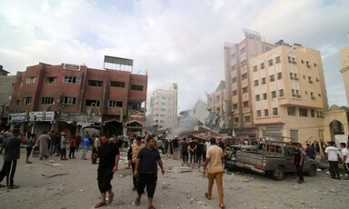 People walk in the city of Rafah after it was attacked by Israel 