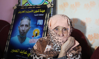 Gaza woman Suad al-Amour sits beside a photographic tribute to her late son Sami